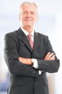 Male Director of a Company Standing with His Arms Crossed and Smiling at the Camera